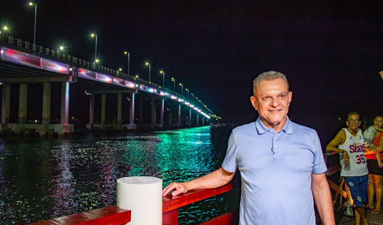 sarto posa para a foto tendo como fundo a ponte com a nova iluminação